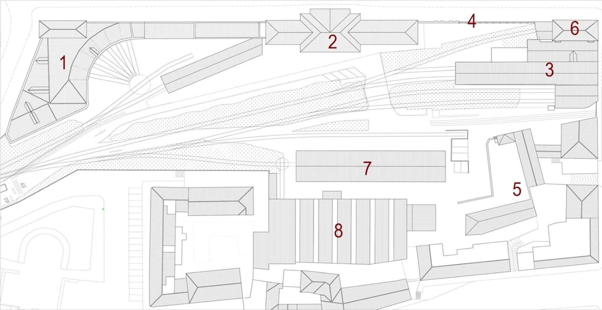 Planimetria generale dell’area di intervento con individuazione dei principali edifici del complesso e delle strutture limitrofe, rappresentate in vista dall’alto e contrassegnate da numerazione progressiva. Il disegno mostra l’organizzazione spaziale dell’intero comparto, sviluppato longitudinalmente lungo il fascio ferroviario, evidenziando il rapporto tra i fabbricati storici, i corpi di servizio e le grandi strutture industriali presenti nel lotto. Sul lato superiore della tavola è riconoscibile il tracciato dei binari e delle aree ferroviarie, che definiscono il margine infrastrutturale del sito e ne determinano l’orientamento. Gli edifici numerati si dispongono parallelamente a questo asse, configurando un sistema lineare composto da corpi di fabbrica di diversa dimensione e tipologia, tra cui volumi storici con copertura a falde, padiglioni produttivi di grande luce e manufatti secondari di collegamento. La numerazione consente di distinguere i diversi elementi del complesso: i fabbricati principali affacciati verso la città, i corpi centrali di distribuzione, le strutture tecniche e i capannoni industriali retrostanti. In particolare, il grande volume centrale con copertura modulare evidenzia la presenza di uno spazio produttivo o espositivo di ampia estensione, mentre gli edifici più piccoli e articolati indicano funzioni di servizio, accesso o collegamento tra le diverse parti del complesso. L’elaborato ha funzione di inquadramento urbanistico e funzionale e permette di comprendere la configurazione complessiva dell’area, le relazioni tra i diversi edifici esistenti e la posizione dell’intervento all’interno del sistema più ampio dell’ex comparto ferroviario-industriale.