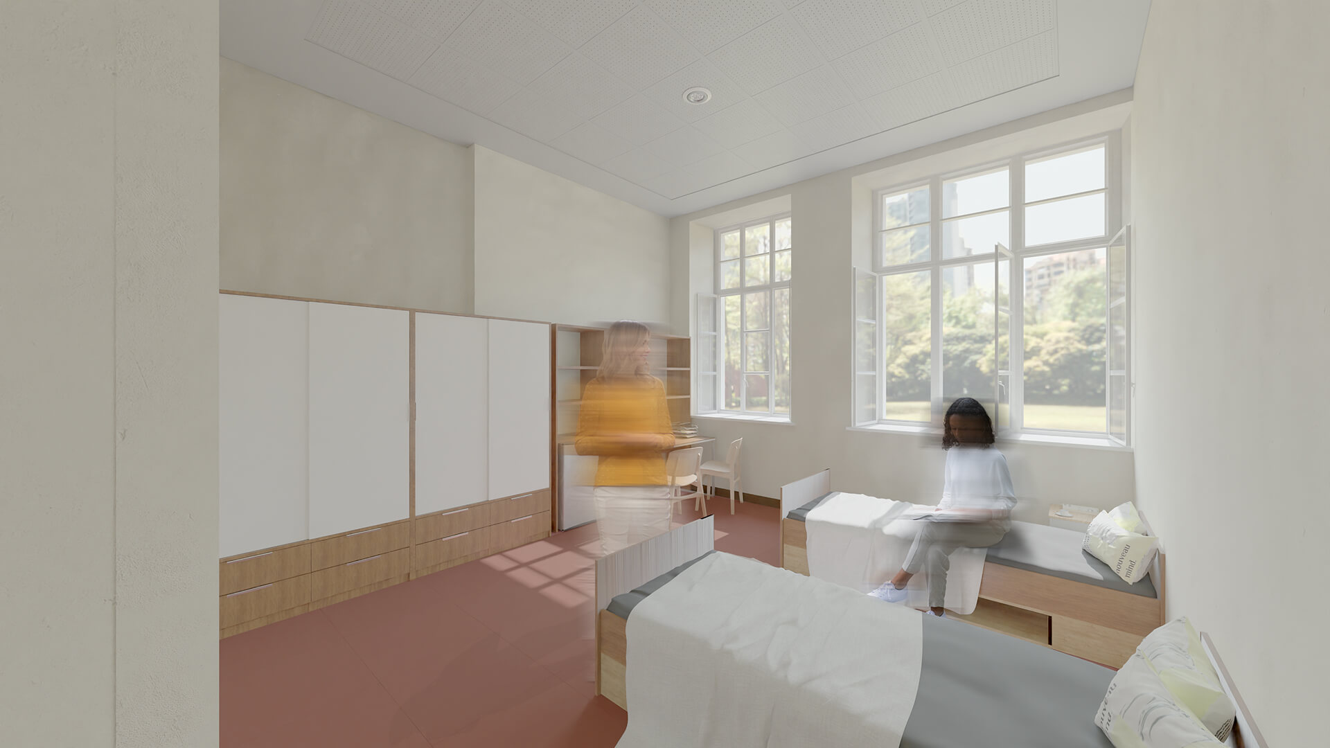 L'immagine mostra una stanza luminosa e moderna, probabilmente parte di una struttura sanitaria o di una residenza, con due letti separati. Le pareti sono di un beige chiaro, mentre il pavimento ha un colore rosso caldo, che conferisce un'atmosfera accogliente. La stanza è dotata di ampie finestre che si affacciano su un ambiente verde, permettendo molta luce naturale di entrare, creando una sensazione di apertura e freschezza. Un armadio bianco e un piccolo ripiano con librerie occupano una parte della stanza, offrendo spazio per l'organizzazione. In primo piano, c'è una persona in movimento, vestita con una maglia gialla, mentre un'altra persona è seduta su uno dei letti, apparentemente immersa nella lettura di un libro. Le persone sono sfocate, probabilmente per dare una sensazione di movimento e dinamicità all'immagine. Il design minimalista e funzionale della stanza riflette un ambiente pratico ma confortevole, adatto ad una struttura di cura o riabilitazione.